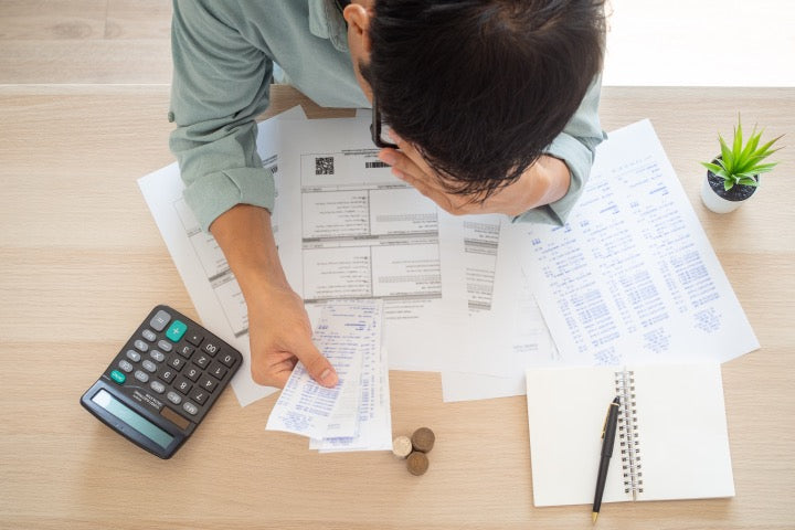 Man looking at energy bill in stress with a calculator